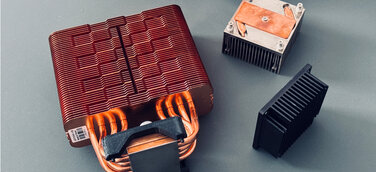Standard cooler, prototype cooler, and 1.5 kg cooper heat sink for the Bitaxe GT.