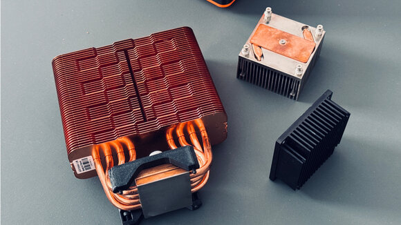 Standard cooler, prototype cooler, and 1.5 kg cooper heat sink for the Bitaxe GT.
